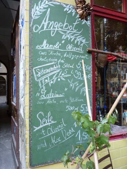 Berlin, Kreuzberg, Tafel mit Inschrift: Angebot Manoli, Olivenoel, Seife, Latzinns und Aloe Vera